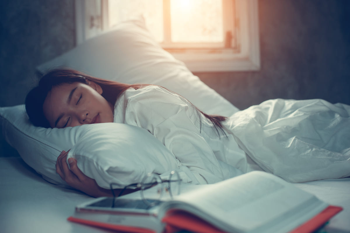 studentessa che dorme con un libro di fianco