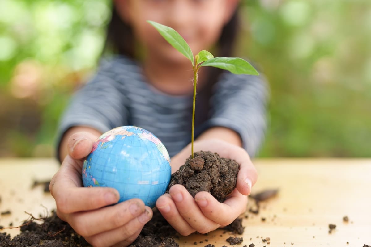 bambina che tiene in mano la terra e un mappamondo