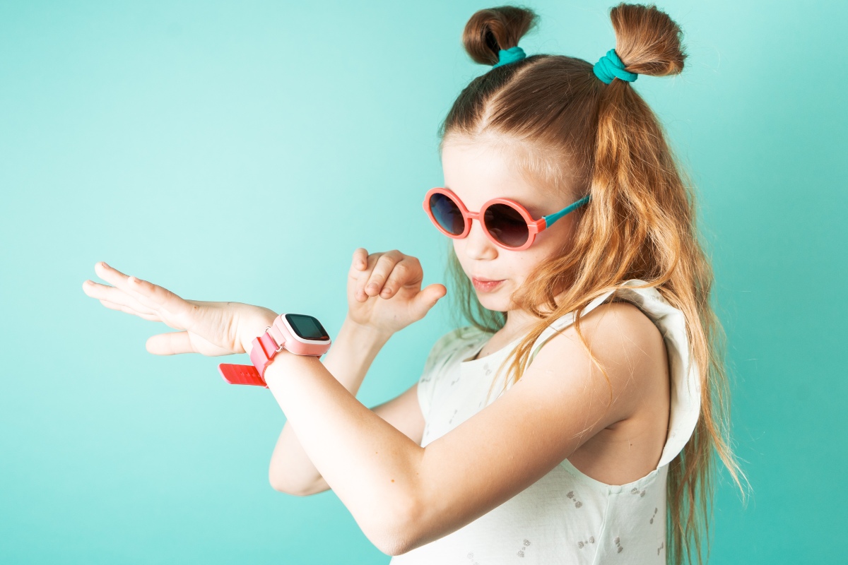 Bambina con occhiali da sole e orologio