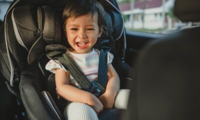 Bambina sorridente seduta nel seggiolino auto