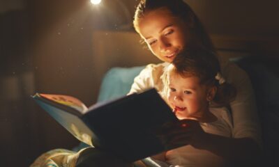 Mamma e figlia nel letto con libro